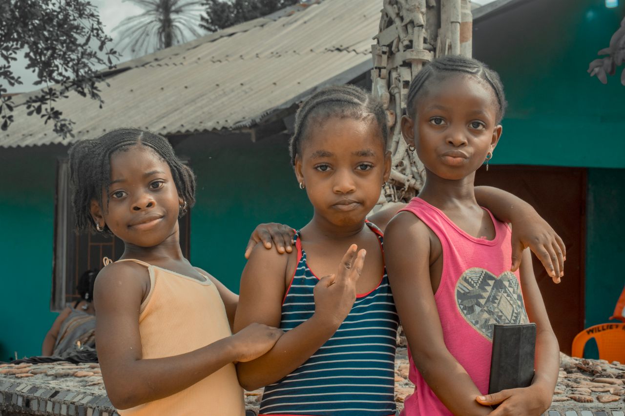 services-01 A group of three smiling African children posing together outdoors in Liberia.
